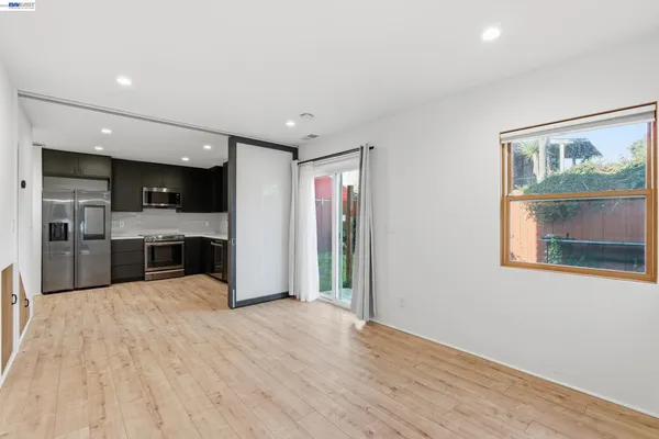 a view of kitchen with stainless steel appliances kitchen island wooden floor and window