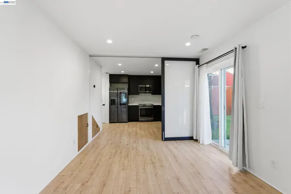 a view of a kitchen with refrigerator and wooden floor