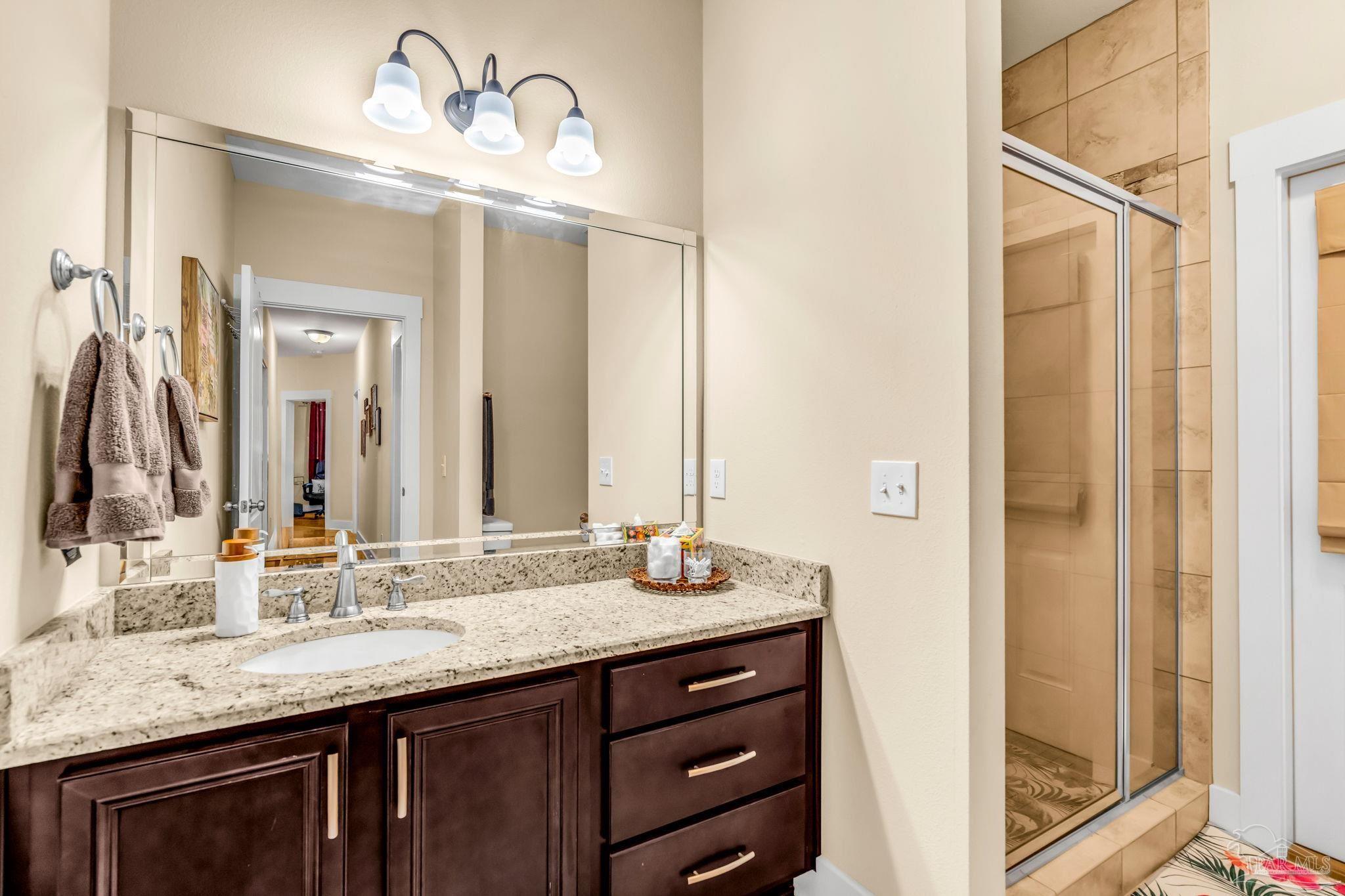 8606 Foxtail Loop Pensacola, FL 32526 - Photo 29 of 57 a bathroom with a granite countertop sink and a mirror