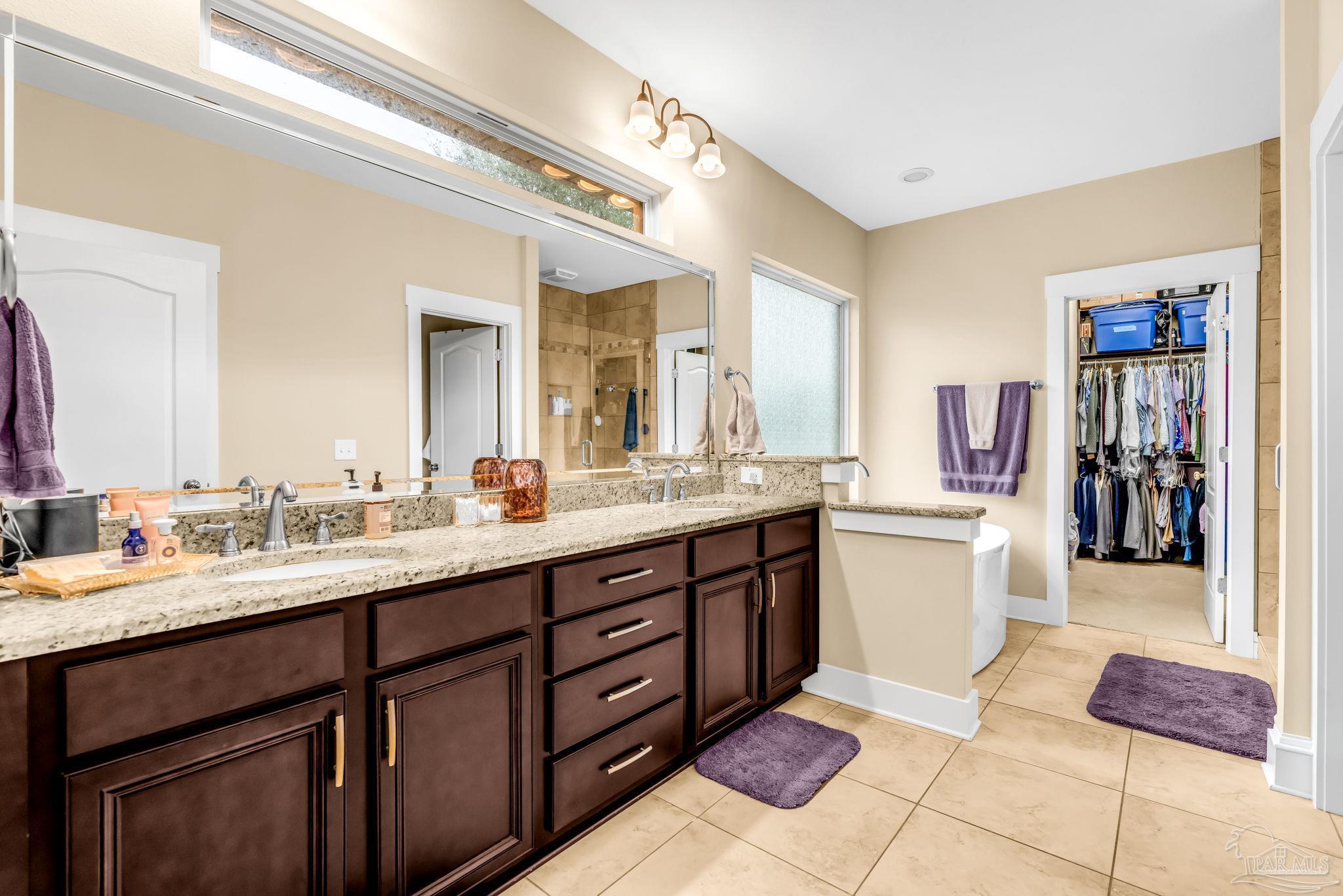 8606 Foxtail Loop Pensacola, FL 32526 - Photo 30 of 57 a spacious bathroom with a granite countertop sink and a mirror