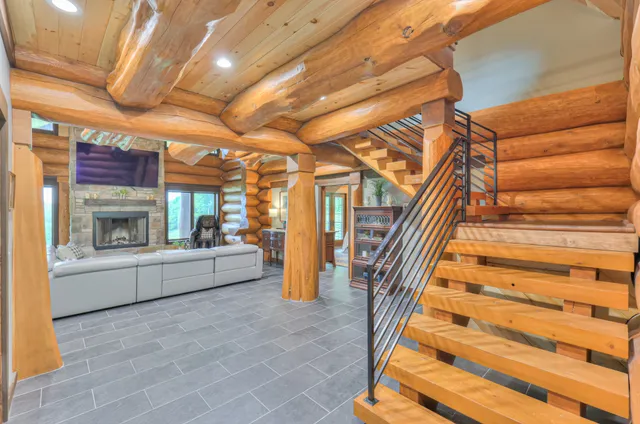 a living room with furniture a fireplace and a ceiling fan