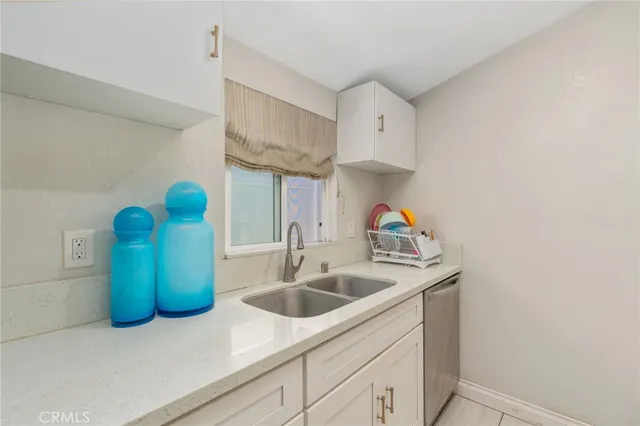 a kitchen with stainless steel appliances a stove a sink and white cabinets