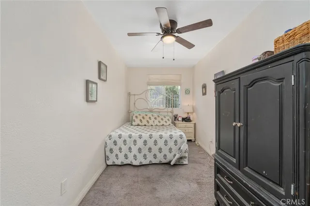 a bedroom with a bed and a chandelier fan