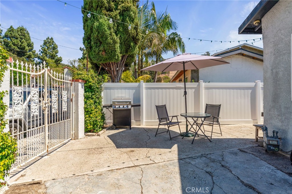 411 South Hewes Street Orange, CA 92869 - Photo 37 of 37 a view of a patio with table and chairs under an umbrella with a fire pit