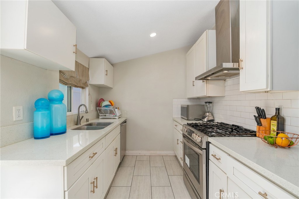 411 South Hewes Street Orange, CA 92869 - Photo 10 of 37 a kitchen with stainless steel appliances a sink a stove and cabinets
