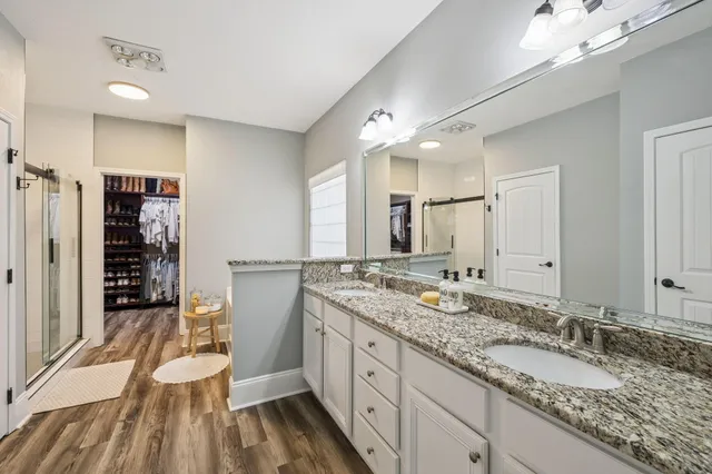 a spacious bathroom with a granite countertop sink mirror and a shower