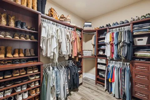 a view of walk in closet with clothes and shoes