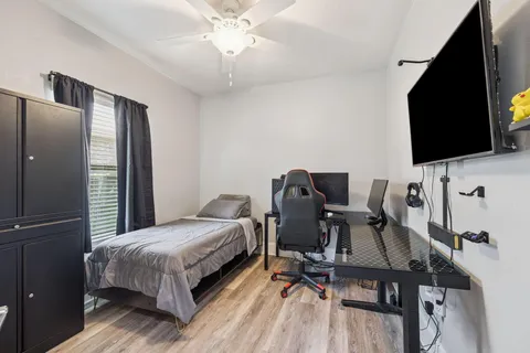 a bedroom with a bed tv and a desk