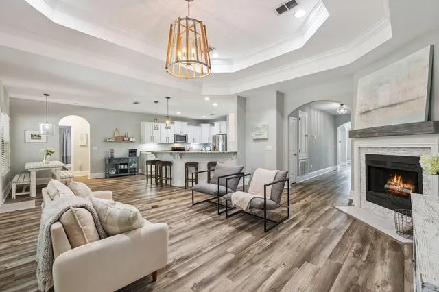 a living room with furniture a fireplace and a chandelier