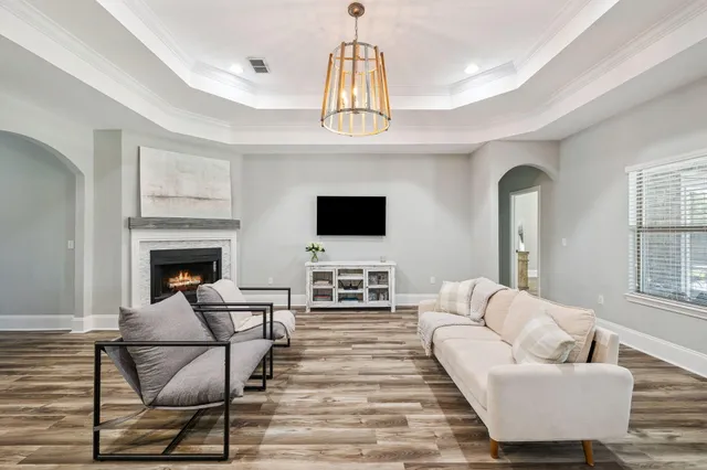 a living room with furniture a flat screen tv and a fireplace