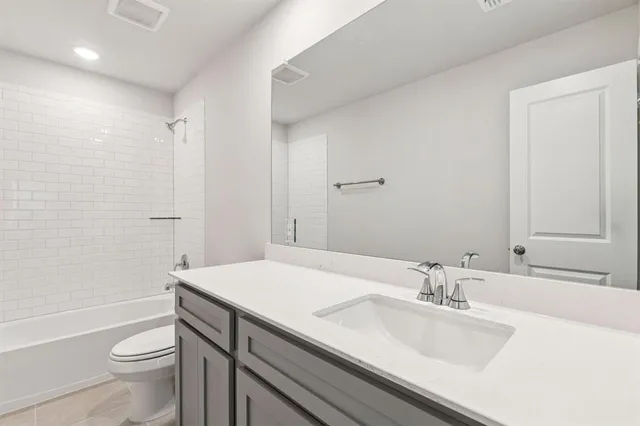 a bathroom with a sink a toilet a shower and a mirror