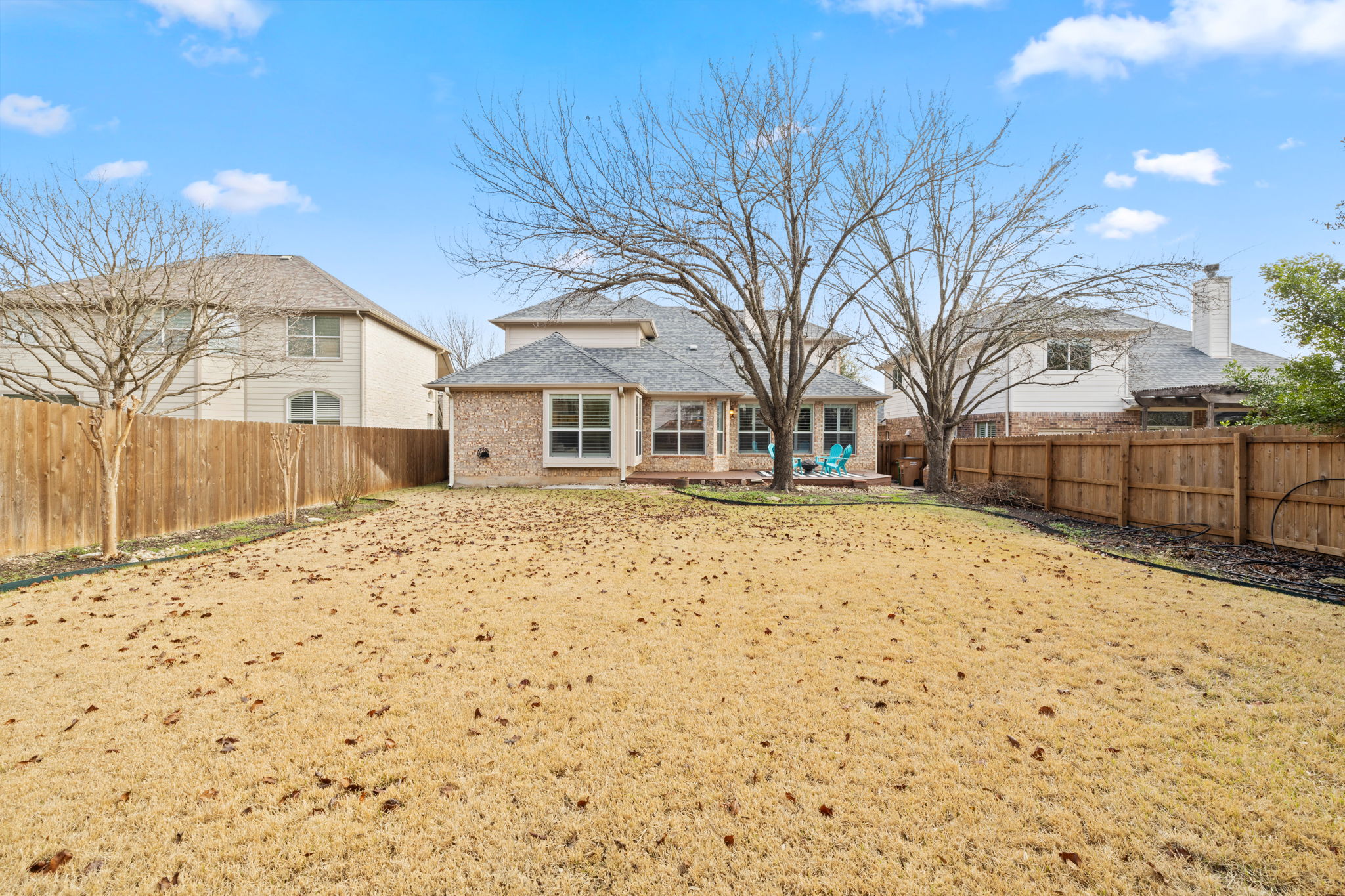 8112 Cobblestone Austin, TX 78735 - Photo 33 of 33 Back of property featuring brick siding, a fenced backyard, a patio area, and roof with shingles