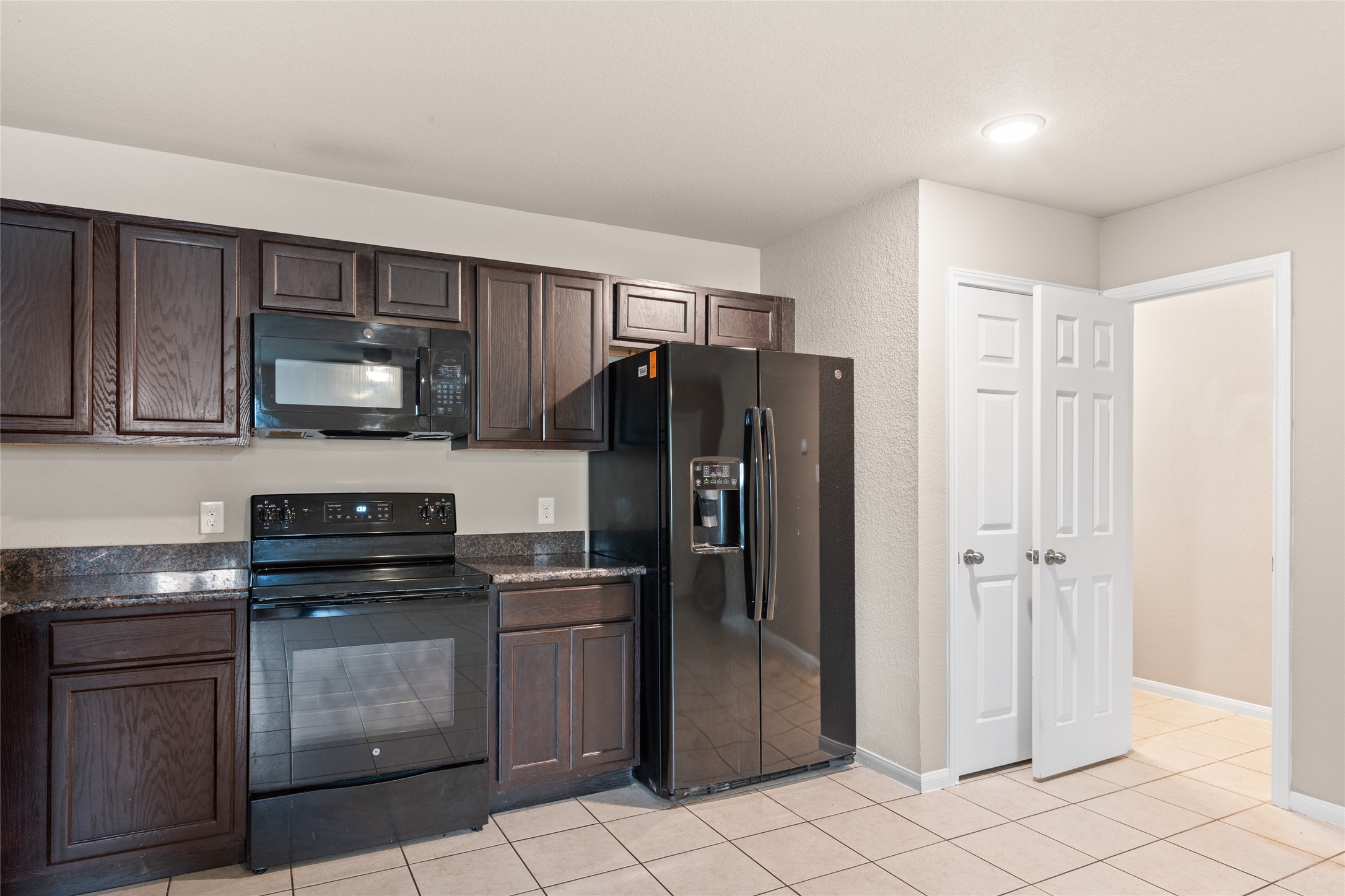 16630 East Hammon Montgomery, TX 77316 - Photo 8 of 14 a kitchen with stainless steel appliances granite countertop a refrigerator and a stove top oven