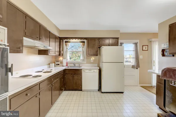 a kitchen with a sink a refrigerator and white cabinets