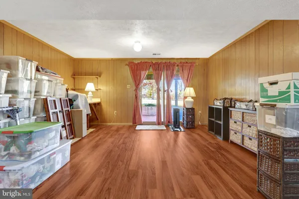 a open kitchen with stainless steel appliances granite countertop a refrigerator a stove top oven a chimney and wooden floor