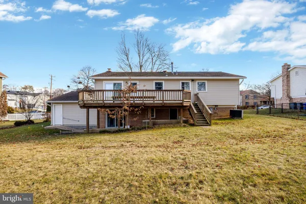 a view of a house with a big yard and large trees