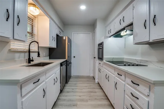 a kitchen with sink a stove and a refrigerator