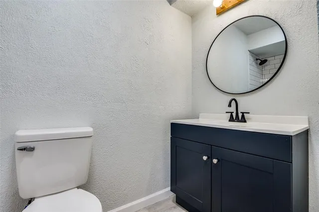 a bathroom with a toilet a sink and mirror