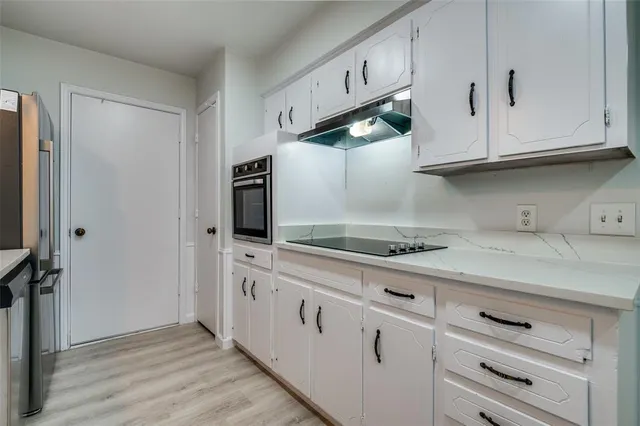 a kitchen with white cabinets and white appliances