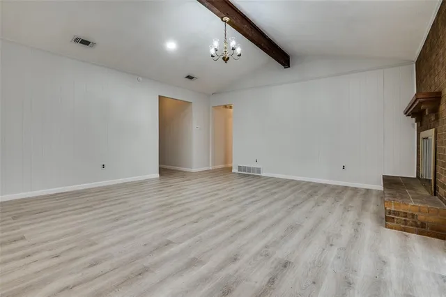 an empty room with wooden floor and a ceiling fan