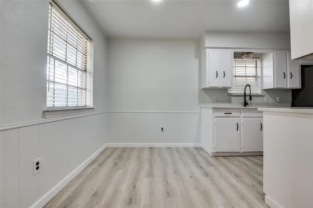 a kitchen with a sink cabinets and wooden floor