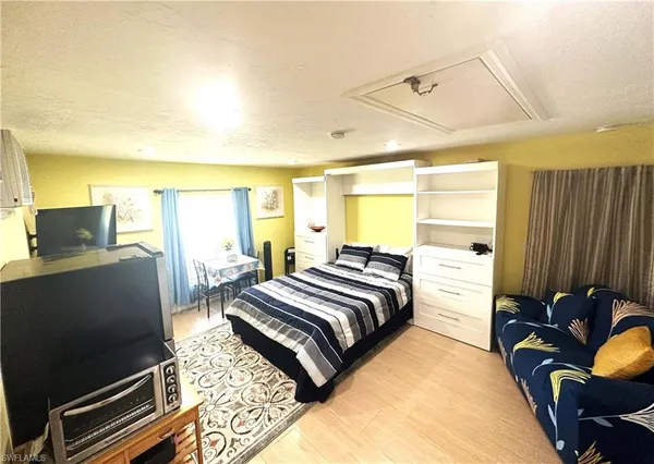 a bedroom with a bed and wooden floor