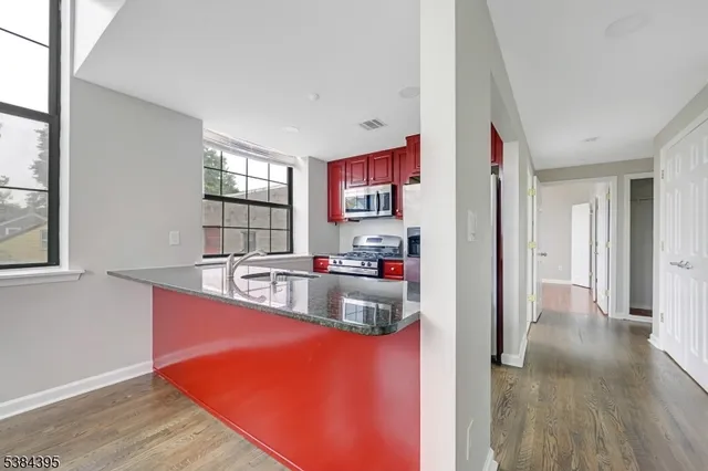 a kitchen with stainless steel appliances granite countertop a sink and dishwasher with wooden floors