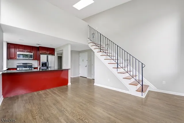 a view of staircase and kitchen with wooden floor