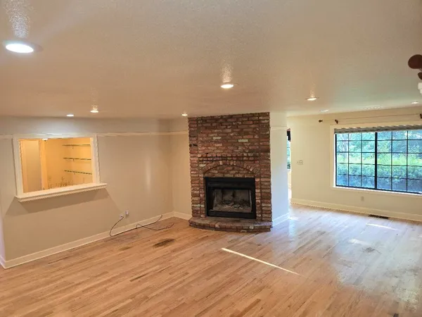 an empty room with wooden floor and a window