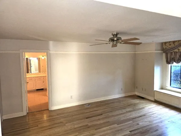 a view of a room with wooden floor and a window