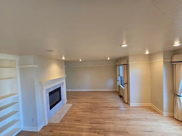 a view of a room with wooden floor and fireplace