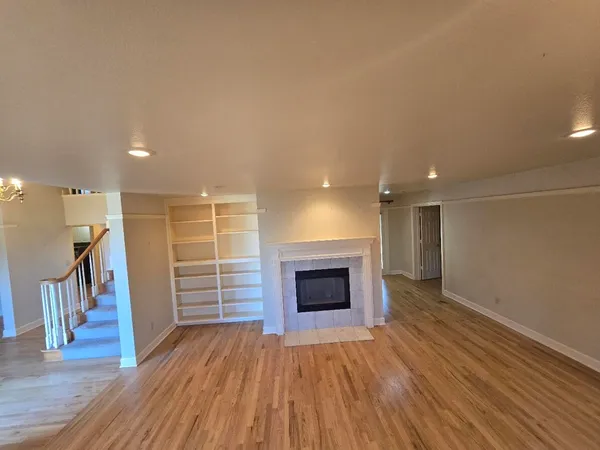 a view of a hallway with wooden floor and a fireplace