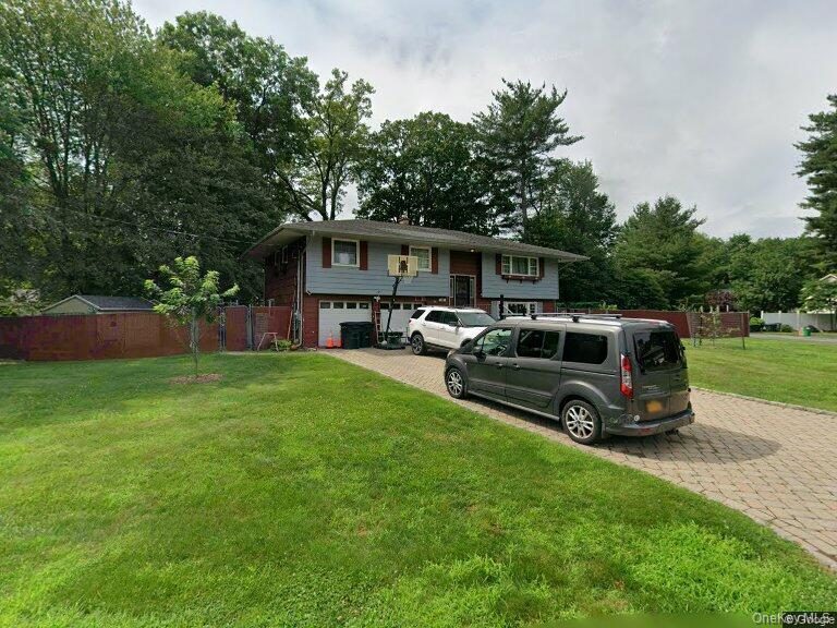 17 Forestdale Road Spring Valley, NY 10977 - Photo 10 of 10 Bi-level home with decorative driveway, view of wooded area, and an attached garage