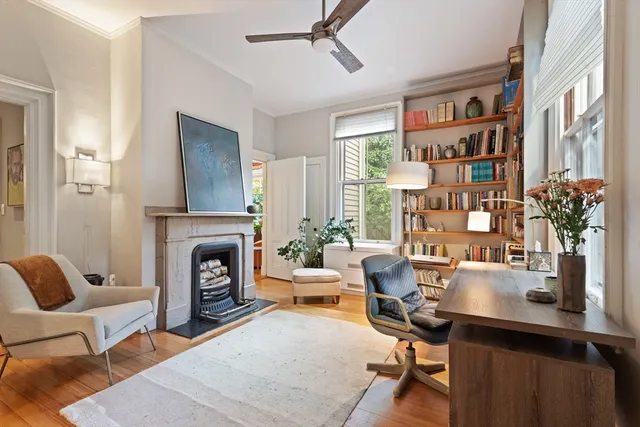 a living room with furniture a bookshelf and a fireplace