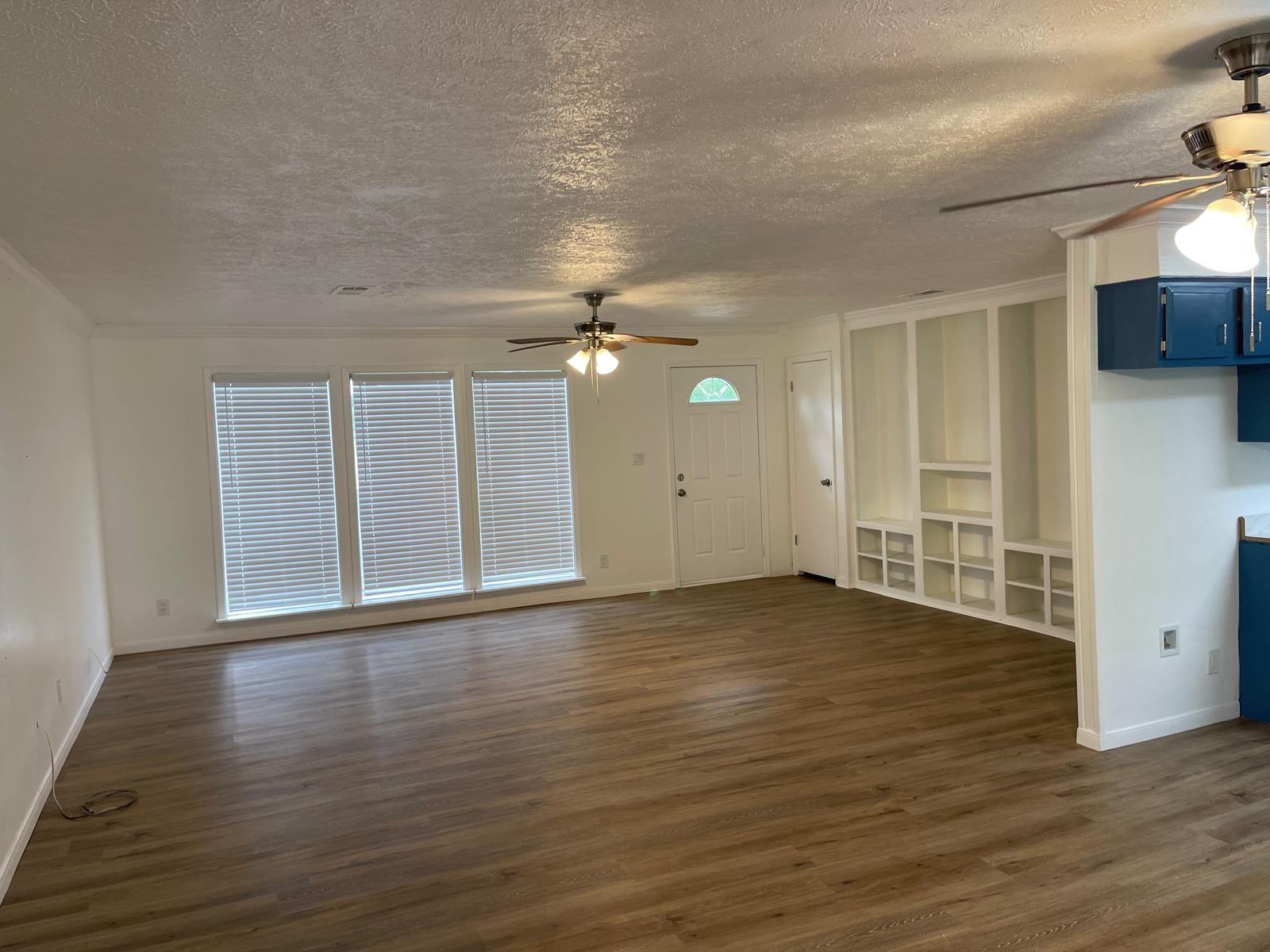 335 Carroll Road Richmond, TX 77469 - Photo 11 of 25 an empty room with wooden floor and windows