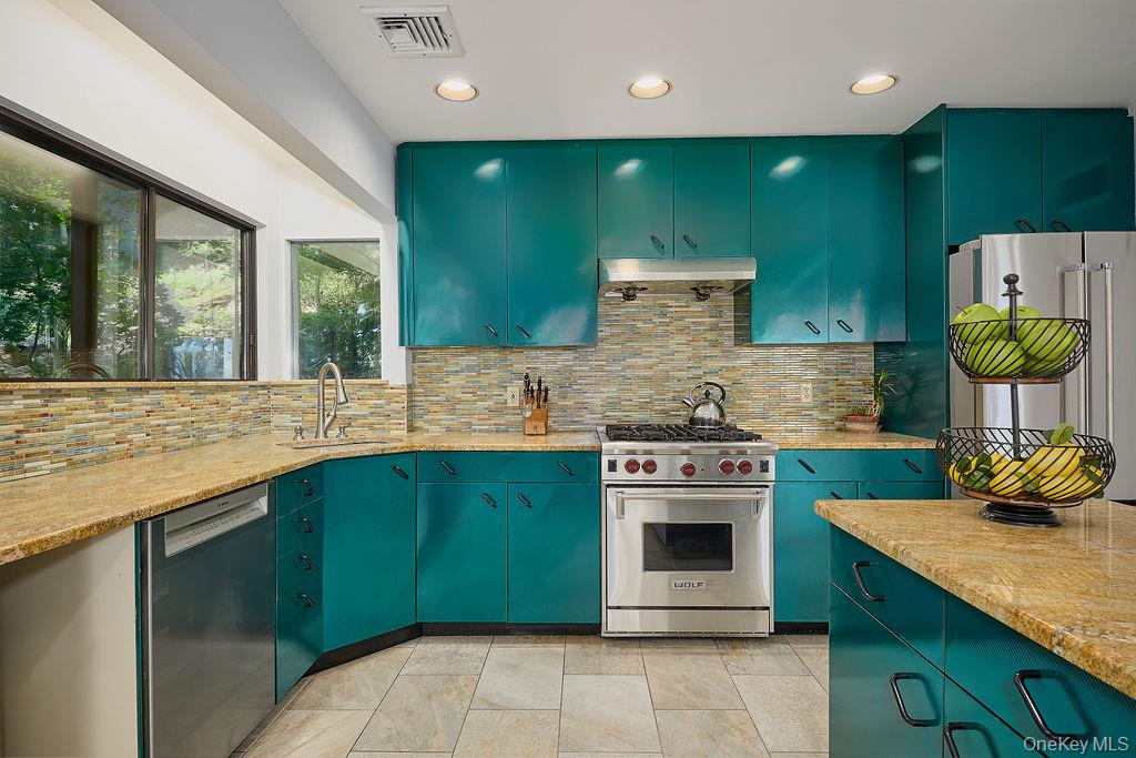 273 River Road Nyack, NY 10960 - Photo 14 of 48 Kitchen featuring teal cabinetry with black hardware, stone tile flooring, and light-toned countertop surfaces