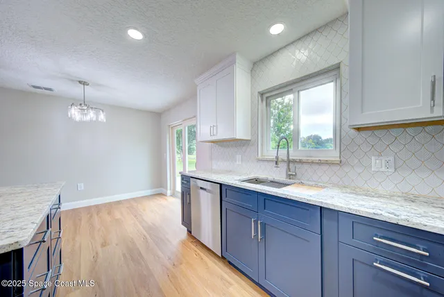 a kitchen with a sink window and cabinets