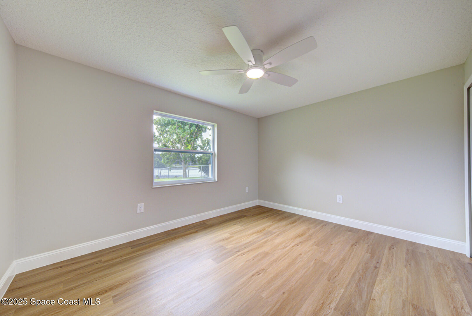 3733 Crossbow Drive Cocoa, FL 32926 - Photo 19 of 25 a view of an empty room with wooden floor and a window