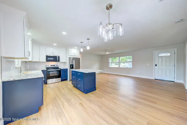 a view of a kitchen with stove top oven and cabinets