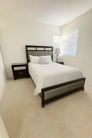 a large bed sitting in a bedroom next to a window