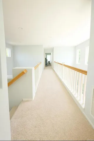 a view of a hallway with wooden floor and a large window