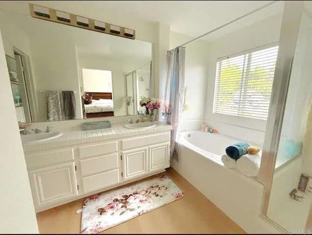 a bathroom with a tub sink and mirror