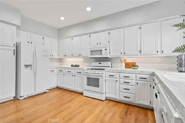 a kitchen with stainless steel appliances white cabinets and a refrigerator