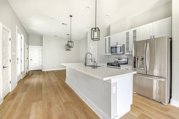 a kitchen with kitchen island a sink appliances and cabinets