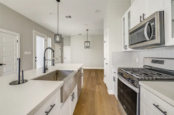 a kitchen with stainless steel appliances granite countertop a stove a sink and a microwave