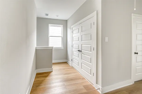 a view of a hallway with wooden floor and staircase