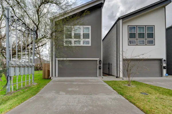 a front view of a house with a garden and plants