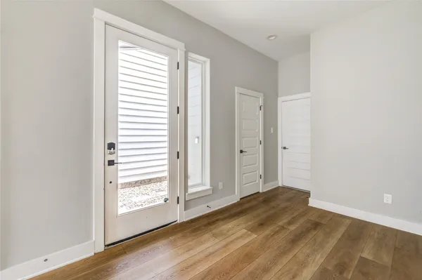 a view of a room with a walk in closet and wooden floor