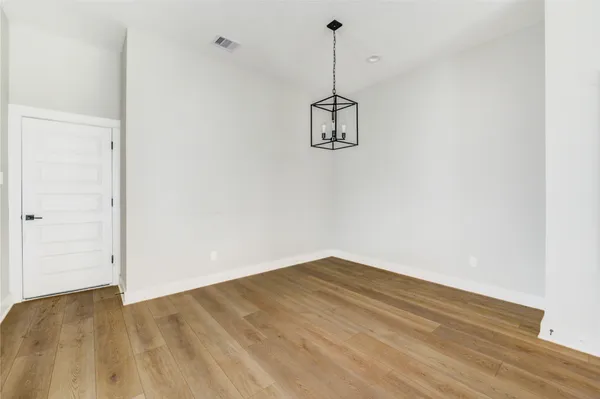 a view of a room with a ceiling fan and wooden floor