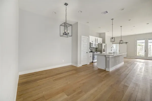 a kitchen with kitchen island white cabinets stainless steel appliances and wooden floor